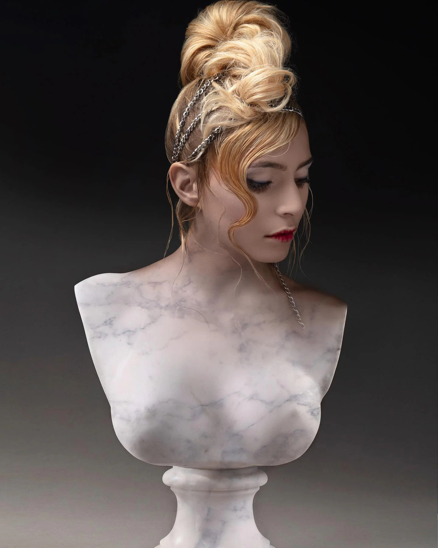 Chignon blond couture orné de chaînes fines sur un portrait sculptural