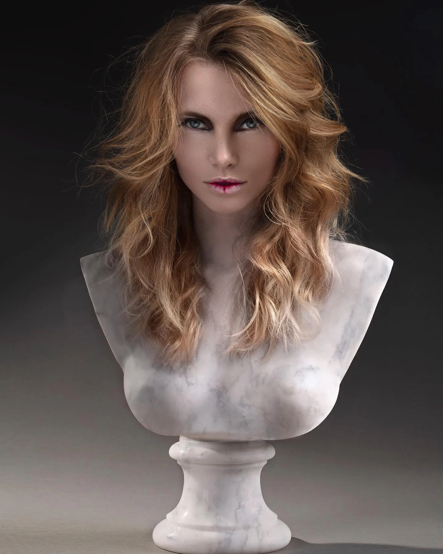 Création coiffure aux longues mèches cuivrées et blondes, présentée comme une sculpture de marbre